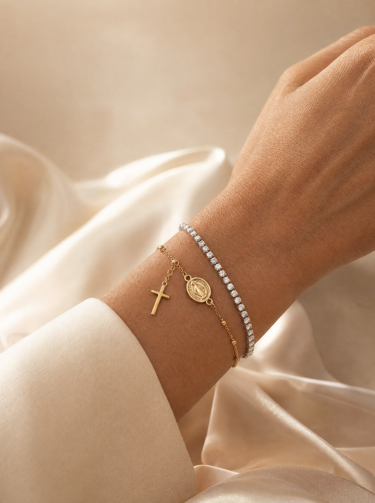 Pulseras de oro de Rosario Joyería puestas en la muñeca sobre tela clara