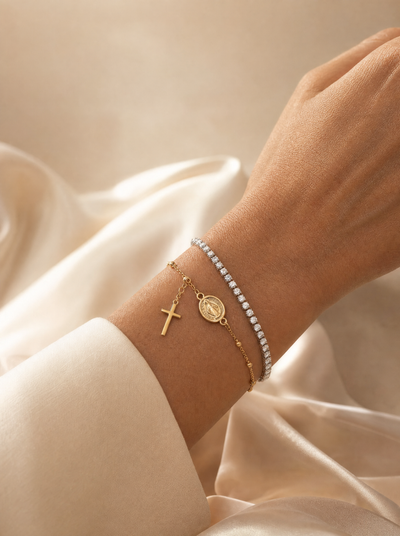 Pulseras de oro de Rosario Joyería puestas en la muñeca sobre tela clara