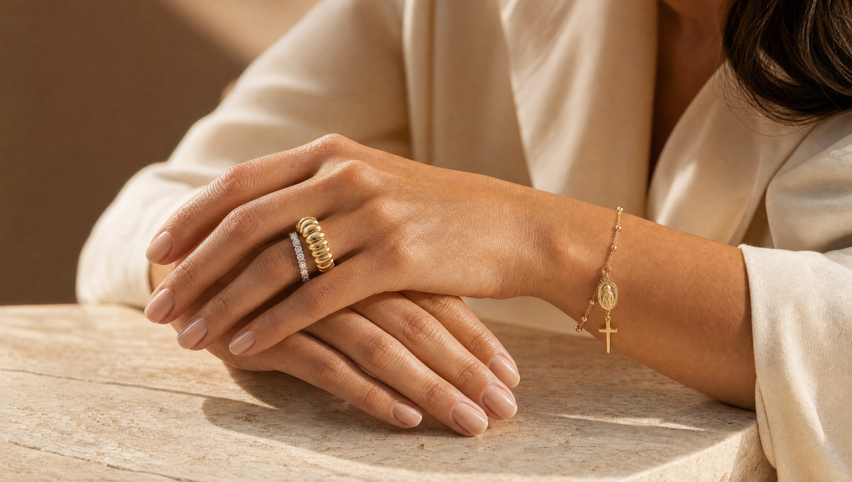 Manos apoyadas sobre mármol con anillos de oro y pulsera de diamantes de Rosario Joyería