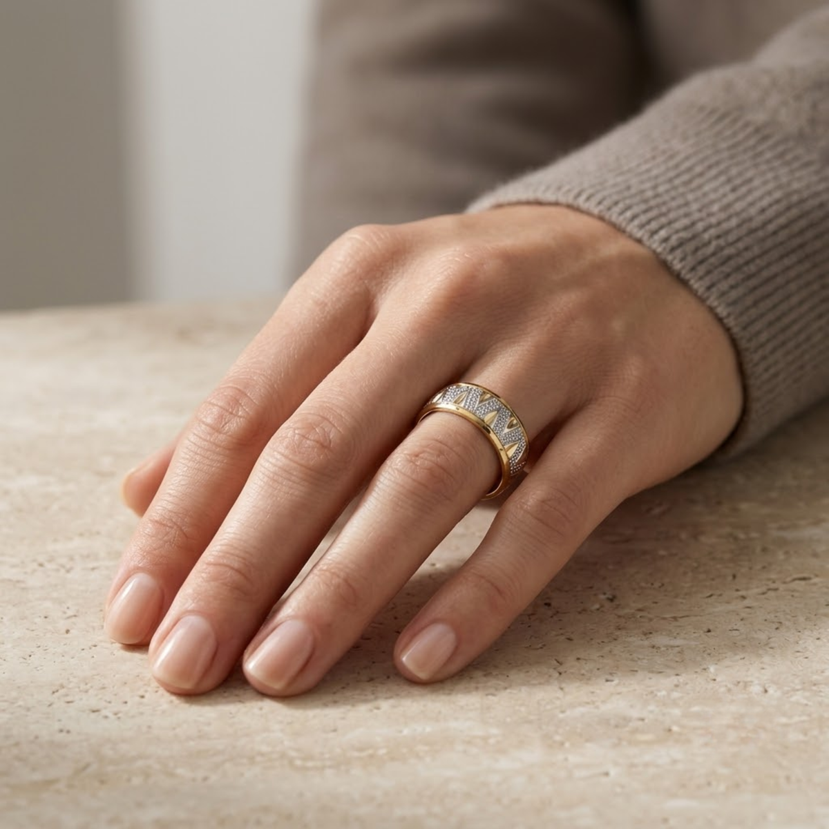 Anillo chevron de oro bicolor 14k puesto en el dedo índice de una mano