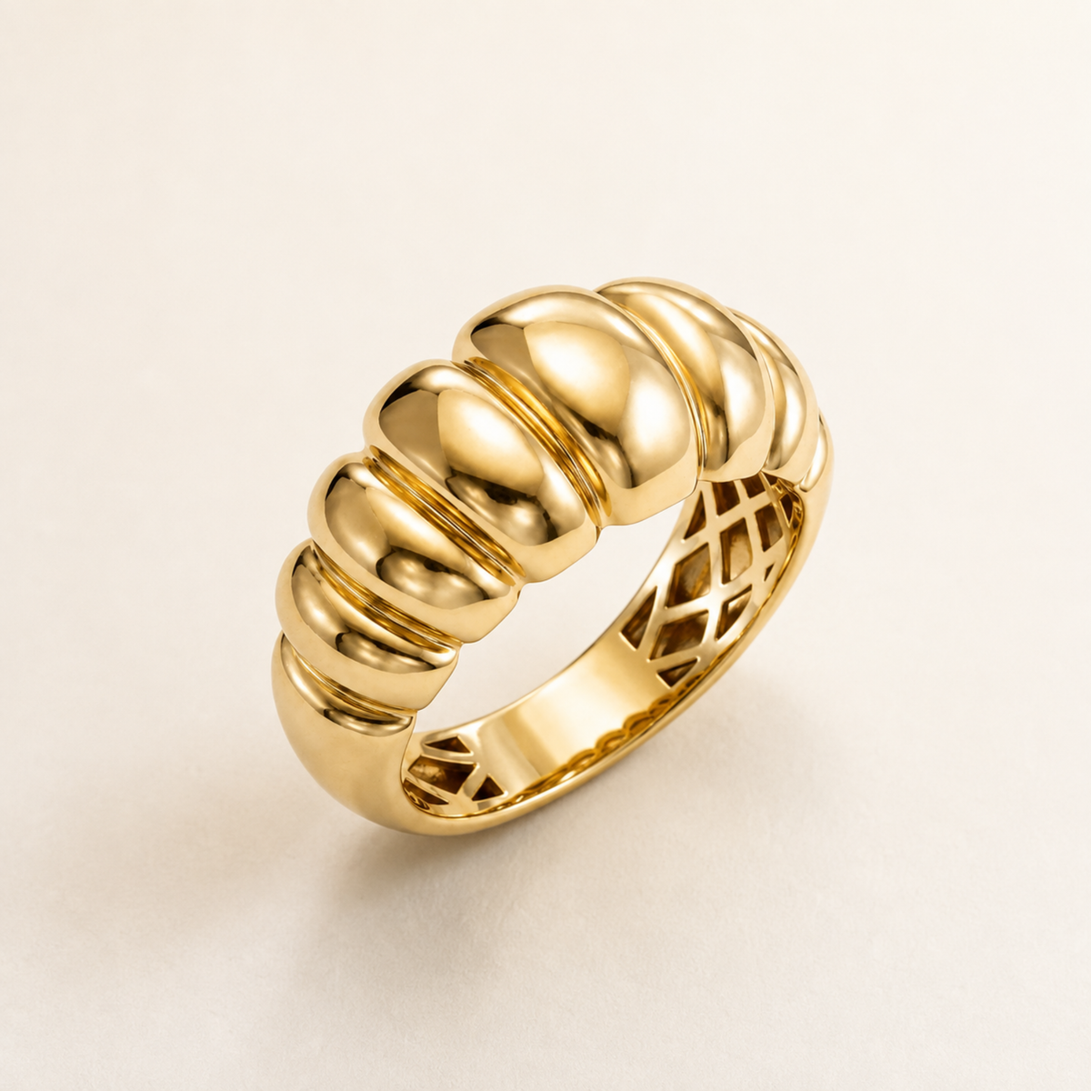 Anillo croissant de oro amarillo 14k puesto en la mano sobre fondo neutro