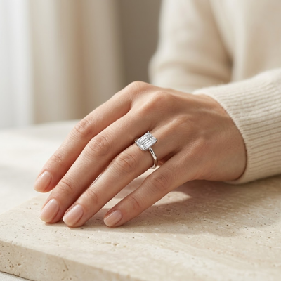 Anillo de compromiso con diamante corte esmeralda puesto en el dedo anular