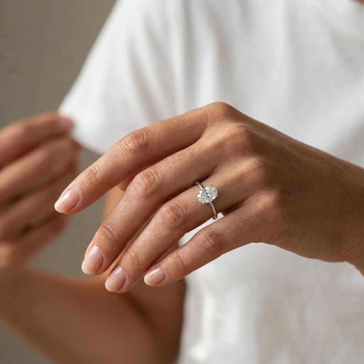 Anillo de compromiso con diamante oval de 2 quilates puesto en el dedo anular