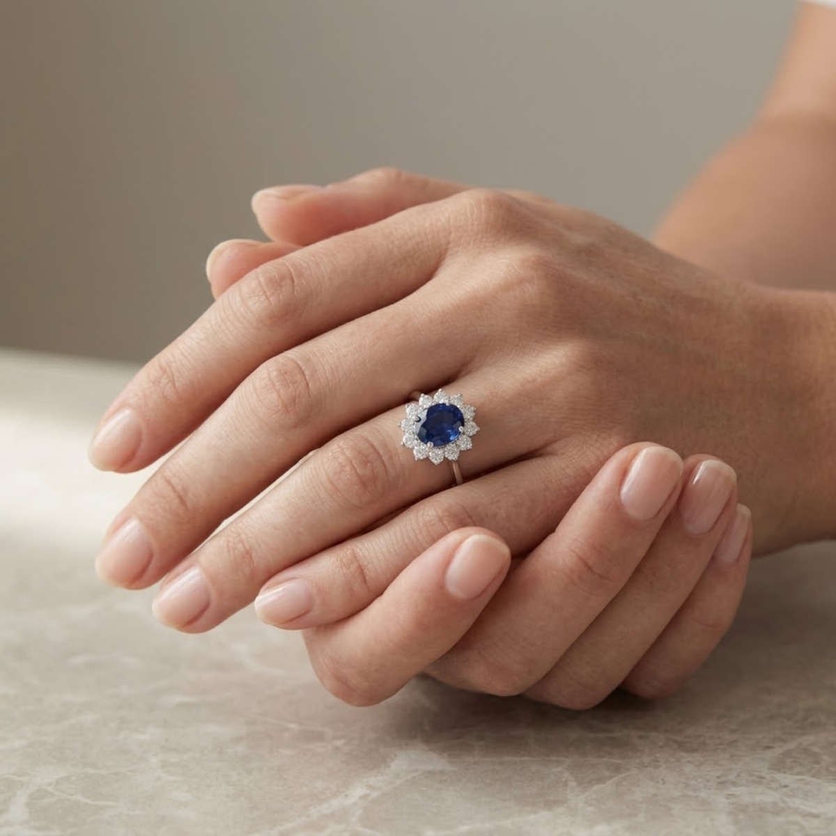 Anillo de zafiro oval con halo de diamantes puesto en la mano